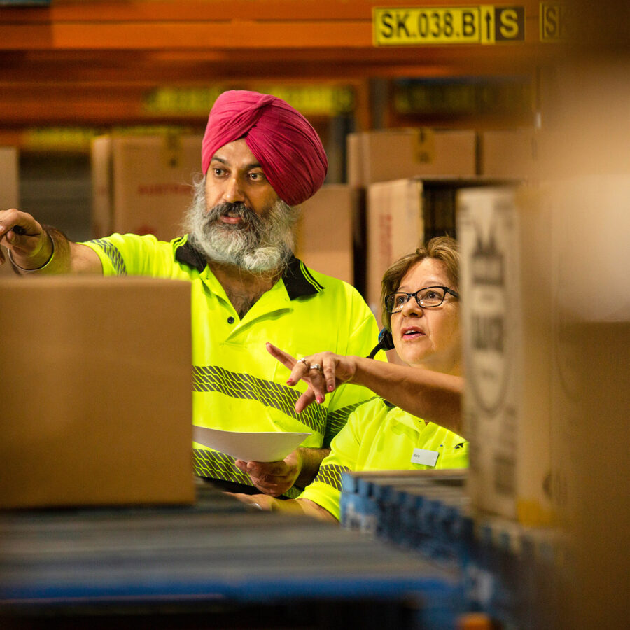 two warehouse workers pointing in same direction