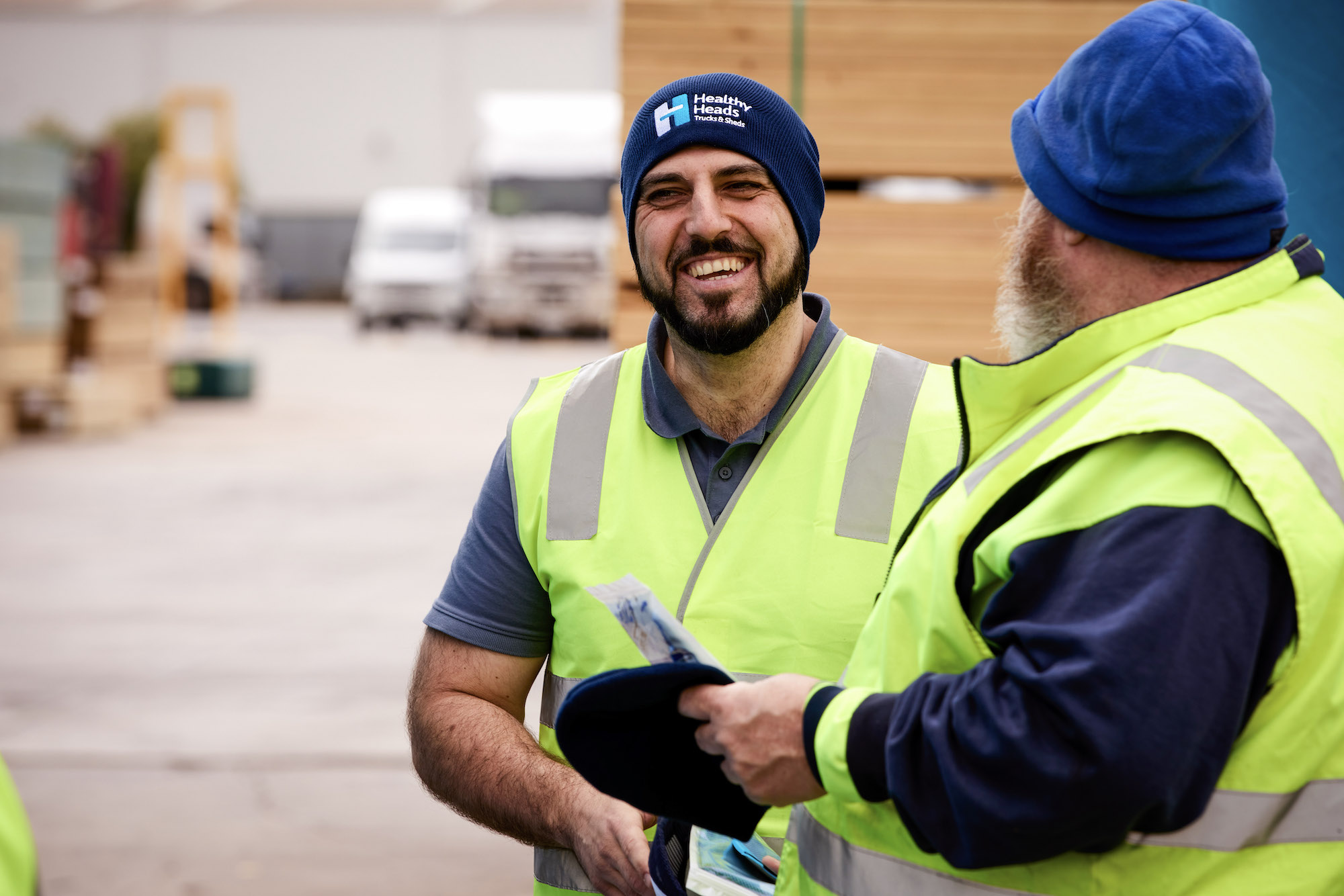 Colleagues with warmer hat smiling and talking